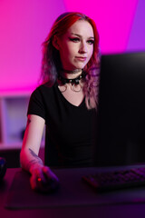 Focused gamer with colorful hair in vibrant gaming setup