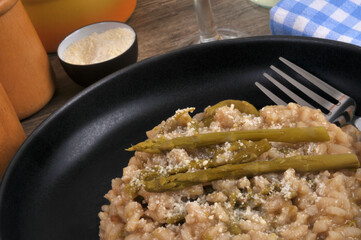 Assiette de risotto aux asperges vertes fait maison avec une fourchette en gros plan