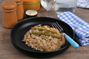 Risotto aux asperges vertes fait maison avec une fourchette servi dans une assiette en gros plan