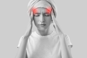 Young man after chemotherapy suffering from headache on grey background