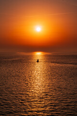 Sea View with a Splendid Sunrise and a boat in the middle f it