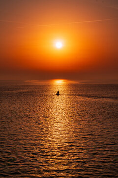 Sea View with a Splendid Sunrise and a boat in the middle f it