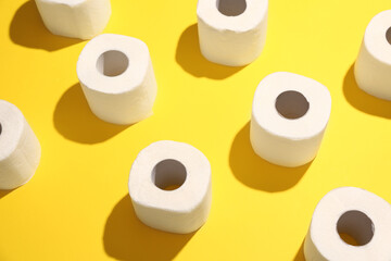 Rolls of toilet paper on yellow background