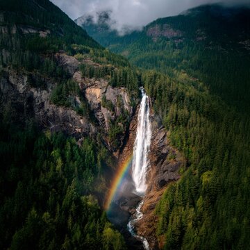 Tall Waterfall with Rainbow in Coniferous Forest