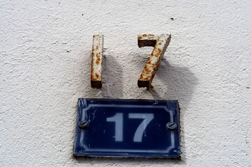 Numéro 17. Numéro répété deux fois. en fer et en chiffres sur plaque blanche et bleu. Numéro de rue.