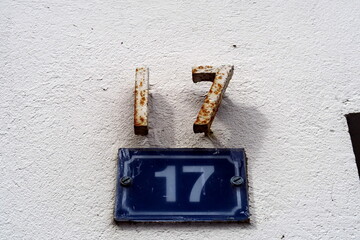 Numéro 17. Numéro répété deux fois. en fer et en chiffres sur plaque blanche et bleu. Numéro de rue.