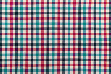 The texture of linen fabric in a large cage of blue, red and white. Scottish tailoring material. Checkered fabric