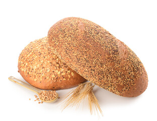 Loaves of fresh bread with wheat spikelets and grains on white background