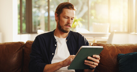 Man, relax and reading on sofa with tablet, social media and ebook for information in home. Person, network or tech in living room for streaming subscription, email notification and download new app