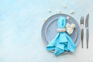 Beautiful table setting with plates,  cutlery, napkin and flowers on light background