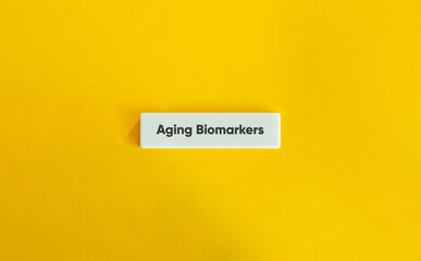 Aging Biomarkers Letter Tile on Yellow Background – Minimalist Health and Longevity Concept