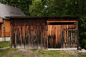 Weathered wooden shed with vertical planks in a rural Serbian village.