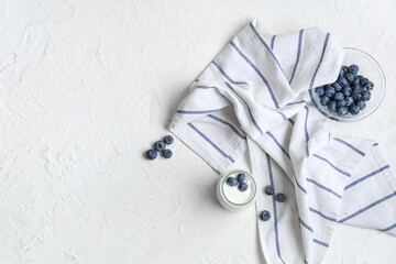 Jar of tasty yogurt with fresh blueberries on white background