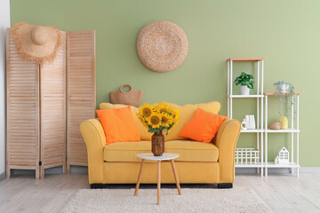 Stylish living room with yellow sofa and vase of beautiful sunflowers bouquet on coffee table