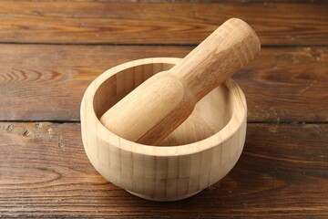 Mortar and pestle on wooden table, closeup