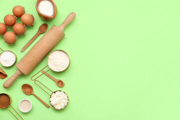 Different ingredients for preparing sweet cinnamon roll on green background