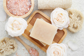 Plakat Soap bars, sea salt, loofah sponges and flowers on white textured table, flat lay