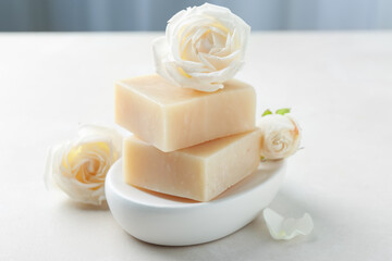Aromatic soap bars and roses on light table