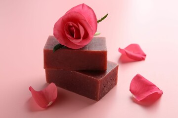 Soap bars and beautiful rose on pink background, closeup
