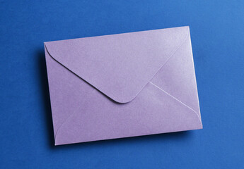 Beautiful invitation envelope on blue background, top view