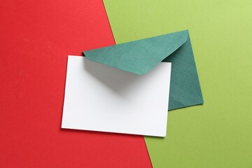 Blank invitation card and envelope on color background, top view. Space for design