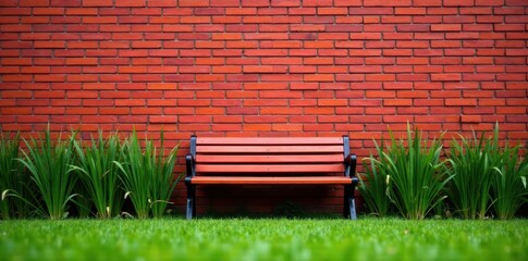 Bench sits alone on red brick wall in green grass with long sedges surrounding it, outdoor furniture, , red bricks