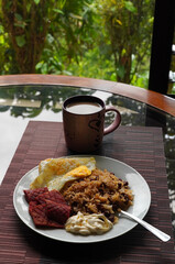 Gallo pinto, a typical Costa Rican dish with rice, red beans, sausage, cream, and a fried egg, and a glass of coffee.