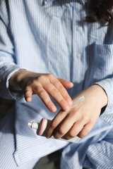 Close up shot of a woman applying hand cream in bedroom, daily skincare routine.