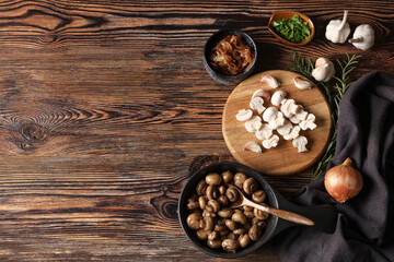 Frying pan with roasted mushrooms and bowl of onion on wooden background