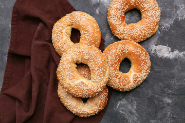 Tasty bagels with sesame seeds on black background