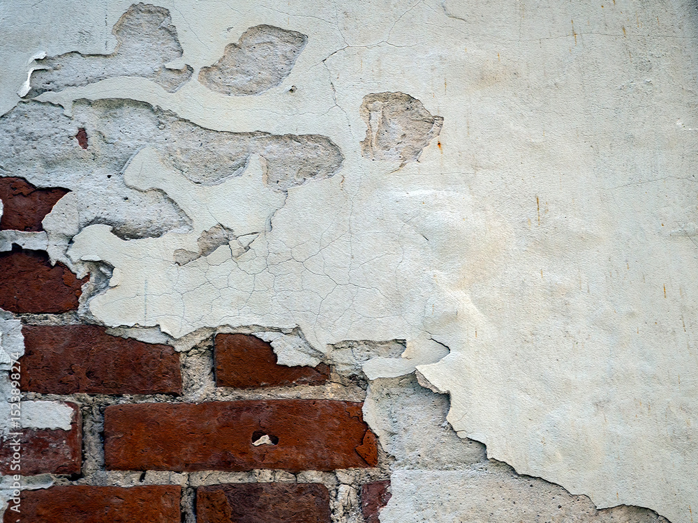Poster abstract background with cracked peeling plaster and red bricks in the bottom corner of the backgrou