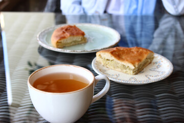 Cabbage pie in a plate on the table, next to the drink sbiten
