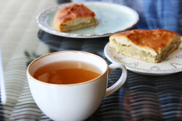 Cabbage pie in a plate on the table, next to the drink sbiten