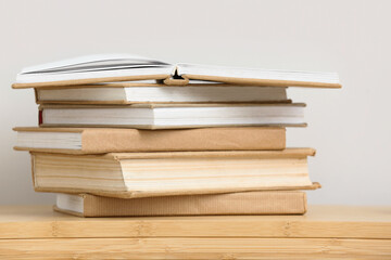 Stack of books on table near white wall, closeup