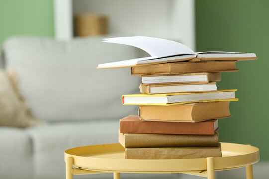 Stack of books on coffee table in living room, closeup