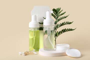 Bottles of micellar water, plaster stands, cotton pads and buds on beige background, closeup