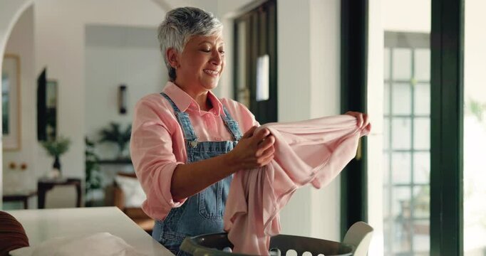 Mature woman, cleaning and smelling laundry with basket for housekeeping or chores at home. Female person, maid or cleaner with smile for fabric, clothing hygiene or garment disinfection at house