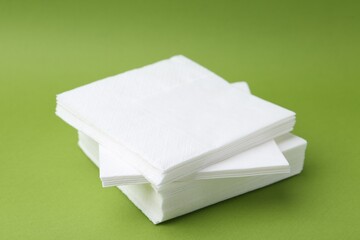 Stack of white handkerchiefs on green background, closeup