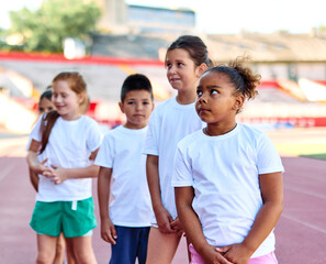 Young children having athletic exercise class running on the track, healthy lifestyle and children sport education concepts