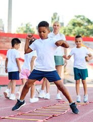 Young children having athletic exercise class running on the track, healthy lifestyle and children sport education concepts