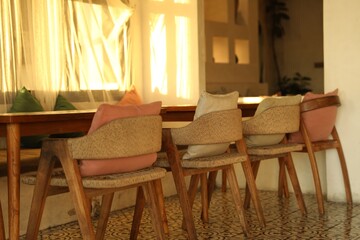 Wooden table and chairs near window indoors