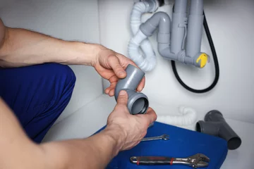Gordijnen Plumber fixing pipes under sink indoors, closeup © New Africa
