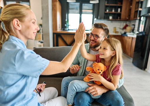 Young father with little daughter child do checkup examination at pediatrician in clinic. Healthcare concept. Woman doctor hold stethoscope listen to girl patient heart chest in hospital.