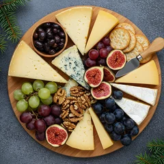 Fototapete cheese board with various cheeses, grapes, nuts, figs, and crackers, festive greenery around.   © ❤  Nancyvoz68❤ 