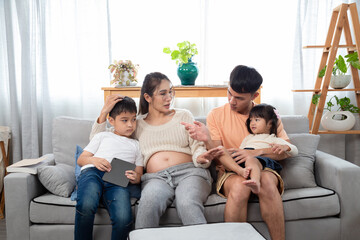 Young Asian parents help their children with homework. mom and dad teach daughter and son to draw...