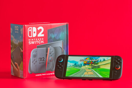 Fukuoka, Japan - june 7, 2025 : nintendo switch 2 game console running 2025 famous game Mario Kart world and console packaging isolated on red background