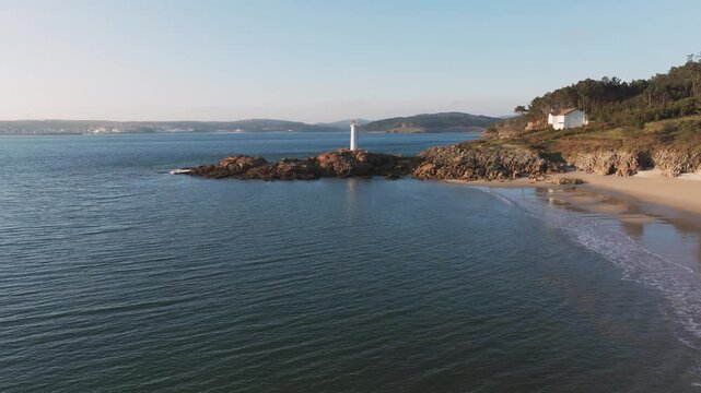 Quiet Sandy Beach Near The Fazo baliza do Lago Lighthouse In Muxia, A Coru&ntilde;a, Spain. - aerial shot