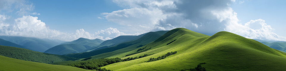 Panoramic view of lush green hills under blue sky with dramatic clouds