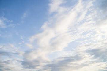 Real beautiful bright blue sky with scattered white multilayer clouds on sunny day before sunset. Sky view. Skyscape. Peaceful cloudscape with altostratus and cumulus clouds background 