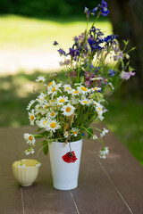 Frühlingsstrauß in einer Vase auf dem Tisch im Garten